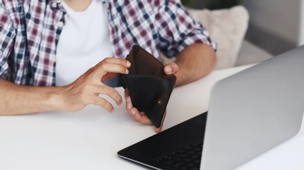インターネット詐欺 オンライン詐欺 フリーランスの仕事のリスク 認識できない壊れた貧しい男の手明らかに空の財布で職場でノートパソコン — ストック写真