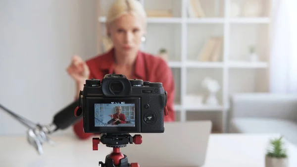インフルエンサーVlog ライブストリーミング オンラインコーチング 熟女ブロガー女性話して録画ビデオインタビュー上のカメラの三脚に焦点を当てたインテリアとともにフリースペース — ストック写真