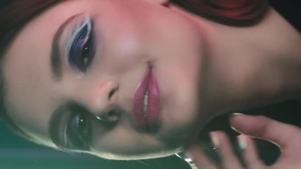 垂直录像 90年代的女孩 艺术化的化妆 复古时尚外观 深蓝色霓虹灯下紫色眼影粉红唇少女笑脸的画像 — 图库视频影像
