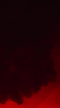 Dikey video. Suyu boya. Mürekkep bulutu. Flaş ışığı. Patlama sisi. Neon mavisi yanıp sönen duman, koyu siyah soyut sanat arkaplan çekimine yayılıyor..