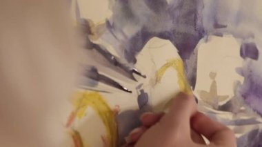 Vertical video. Artwork painting. Visual art. Hobby inspiration. Female artist hand creating yellow blue color abstract picture with wax crayon on paper.