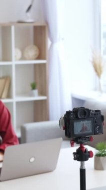 Dikey video. Vlog akışı. Çevrimiçi koçluk. Üst düzey nüfuzlu kadın kameraya içeriği kaydediyor. Odaklanamayan ışık huzurevinde. Boş alan var..