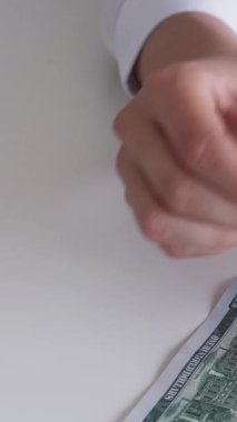 Dikey video. Finansal gelir. Yatırım kârı. Ekonomi bütçesi. İş kadınının eli para sayıyor. 100 Amerikan doları banknot..