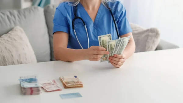 現金だ 医療の破損 医療費だ 認識できない豊かな女性医師カウント100法案アメリカドルお金オンソファ — ストック写真