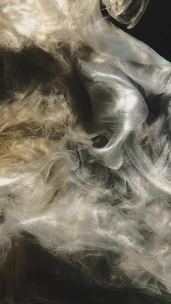 垂直ビデオ インクの水 キラキラした霧 流体のスプラッシュ 暗い黒の抽象的な背景に黄金の銀輝く塵粒子浮遊水蒸気雲の流れの動き — ストック動画