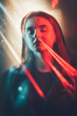 Hayalet portresi. Öbür dünya gizemi. Kırmızı mavi ışık, sakin kadının yüzünü siluet kaplamış, gözleri kapalı uyuyan polietilen plastik bir film..