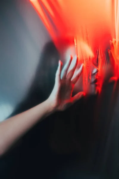夜间恐怖 变态的谜 红色光与焦距分离的令人毛骨悚然的女人轮廓触摸划破的塑料聚乙烯膜透明墙 — 图库照片