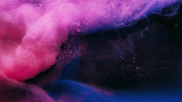 Neon smoke. Paint water. Vapor wave. Dreamlike cloud. Bright pink blue purple color haze flow on dark black abstract copy space background.