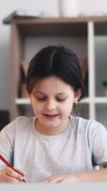 Dikey video. Sanat okulu. Mutlu küçük kız. Hobi olarak. Gülümseyen kadın çocuk stüdyo içinde kağıt üzerine çizim yapmaktan zevk alıyor..