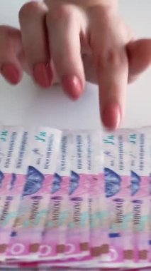 Dikey video. Para geliri. Finansal bütçe. 200 Ukrayna Hryvnia kağıt para yığını kadın eli sayıyor..