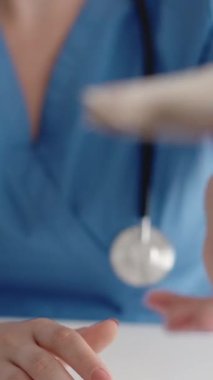 Dikey video. Sağlık sigortası ödemesi. Tıbbi gelir. Tanımlanamayan kadın doktor elleri hastadan 50 'lik banknotları sayarak para alıyor..