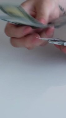 Dikey video. Döviz bürosu. Para politikası. Dünya ekonomisi. Kadın yöneticinin eli kulağında. Avro banknotlu nakit yığınından Amerikan doları sayıyor..