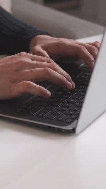 Dikey video. İnternet işi. Dijital pazarlama. İnternet araştırması. Bilgi teknolojisi. İş yerinde dizüstü bilgisayarda yazan erkek işçilere yakın çekim.