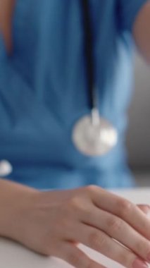 Dikey video. Doktor ücreti. Sağlık sigortası ödemesi. Tanımlanamayan kadın doktorların eli hastadan para alıyor. 100 Amerikan doları nakit para sayıyor..