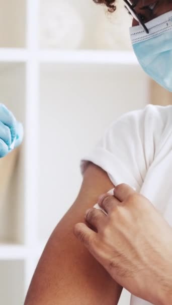 垂直ビデオ インフルエンザワクチン接種 病気の予防 免疫注射だ 医師で手袋接着剤包帯後にジャブショットへ男性患者腕肩 — ストック動画