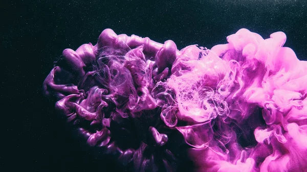 Ink splash. Color smoke. Paint water. Fantasy magic. Purple pink color glossy fume cloud dust particles on dark black abstract art background with free space.
