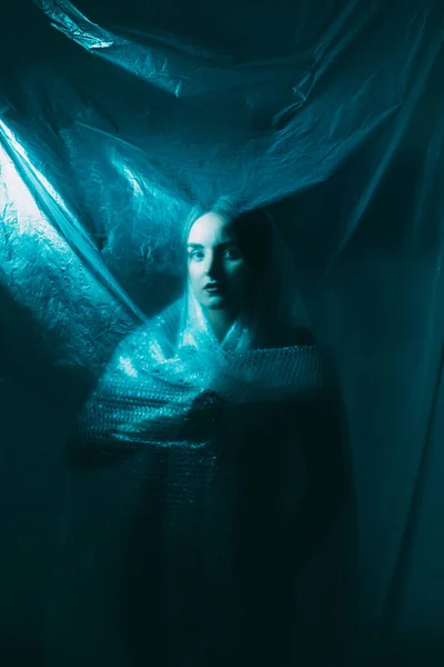 ゴースト女性ヴィンテージの肖像画 幽霊のような謎だ 冷たい青の光が焦点を当てた女性の後ろにかなり顔のシルエット暗い上のしわポリエチレンプラスチックフィルム — ストック写真