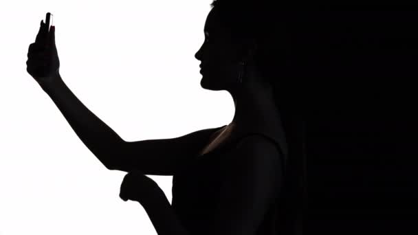 网上调情 视频通话 虚拟通信 女性侧写吹气吻在手机自拍照在白色黑色复制空间背景下 — 图库视频影像