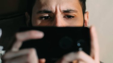 Telefon filmi. Gadget yorgunluğu. Dijital uykusuzluk. Endişeli, korkmuş bir adamın gözleri elektronik cihazdaki dramatik gerilim videosu izliyordu..