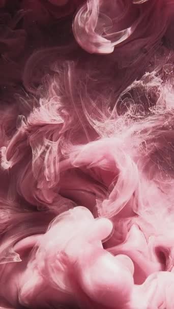 垂直ビデオ 煙が出る ペイントスプラッシュ インクの水 魔法のベール ピンク輝く粒子蒸気運動アブストラクトアートオープナー背景 — ストック動画