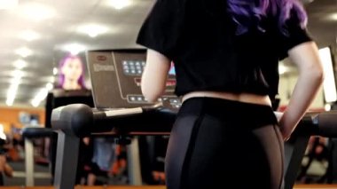 Jimnastik. Fitness eğitimi. Spor motivasyonu. Aktif yaşam tarzı. Mor saçlı atletik bir kadın güç egzersizleri yapıyor. Su içme sekansını kullanıyor..