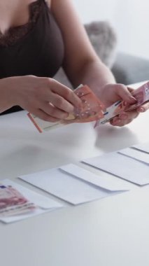 Dikey video. Zarf ödemesi. Yasadışı maaş. Maaş vergisi. Tanınmayan muhasebeci kadın para hesaplıyor Euro banknotları para ayarlıyor.