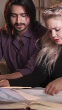 Dikey video. İş koçluğu. Mesleki işbirliği. Şirket yönetimi. Grafikler üzerinde istatistikleri tartışan çok kültürlü iş arkadaşları beyin fırtınası yapıyorlar..