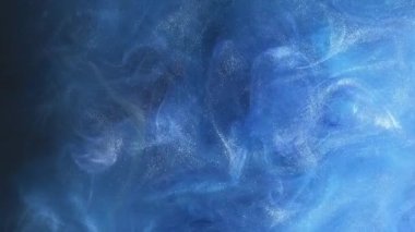 Renk sisi. Parlak toz. Boya suyu sıçraması. Sihirli hava. Parçacık dokusu. Mavi parlayan duman bulutu soyut bir zemin üzerinde yüzüyor..