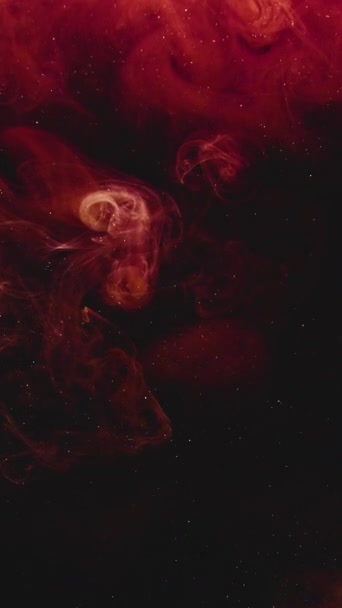 垂直ビデオ 煙爆発だ インクの水 爆風だ 濃い赤オレンジ色の光る蒸気が黒い輝きの塵粒子に飛び散る抽象的なアートの背景 — ストック動画