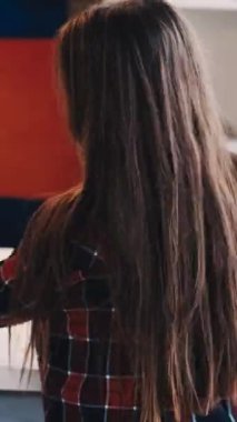 Dikey video. Sanat hobisi. Çocuklar resim yapıyor. Sanatsal aletler. Arkaya bakan küçük kız ışık odası iç dekorasyonu için renkli kalemler hazırlıyor..