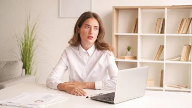 Yorgun iş. Ofis kadını. İlgisiz görevler. Beyaz gömlekli umutsuz bir kadın. Dışarıya bakıyor. İçerideki aydınlık odada oturuyor..