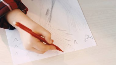 Çocukların yaratıcılığı. Çizen kız. Peri masalı sanatı. Tanımlanamayan küçük çocuk kalem ışığı odalı beyaz kağıda büyük bir ağaç çiziyor..