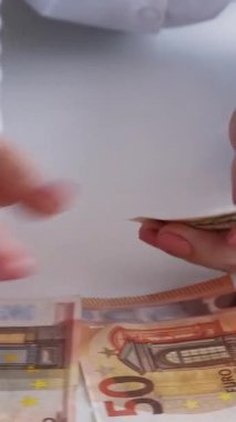 Dikey video. Para yatırımı. Kâr değeri. Uluslararası ticaret. Gelir sayan kadın eli sayısı 50 euro nakit kağıt banknotlar.