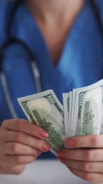 Dikey video. Doktor rüşveti. Tıbbi yozlaşma. Sağlık vergisi. Tanımlanamayan sahtekar kadın doktor para sayıyor 100 Amerikan doları nakit..