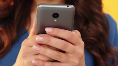 İnternetten alışveriş. İnternet satışı. Elektronik ödeme. Sipariş teslimi. Mutlu sürpriz kadın cep telefonu uygulaması kullanıyor kredi kartı sarı arkaplan çekimleri için çantalar alıyor.