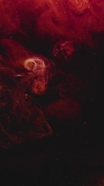 垂直ビデオ 煙爆発だ インクの水 爆風だ 濃い赤オレンジ色の光る蒸気が黒い輝きの塵粒子に飛び散る抽象的なアートの背景 — ストック動画