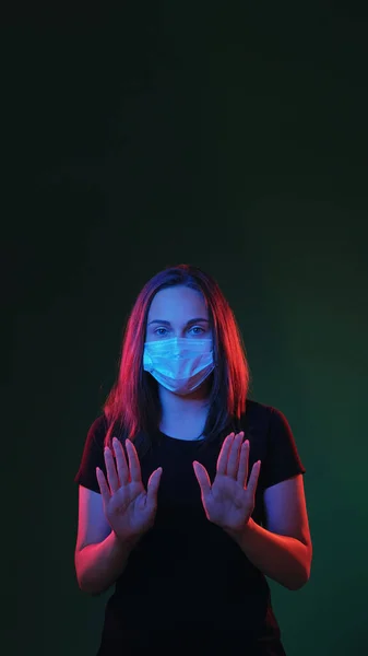 Quarantine measure. Stop air pollution. Red blue neon color light girl in protective mask warning coronavirus pandemic danger on dark green empty space background.