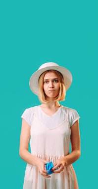 Salgın hijyen. Grip önleme. Beyaz maskeli, üzgün, yorgun bir kadın, turkuaz uzay arka planında izole edilmiş virüs yüzünden kendini kötü hissediyor..