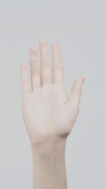 垂直ビデオ ジェスチャー 挨拶の印だ 光を背景に手を振る女 — ストック動画