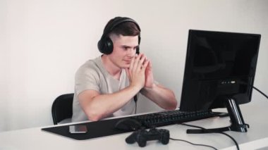 Kurnaz oyuncu. Bekleyen adam. Kulaklıklı yakışıklı bir adam. Ellerini birbirine bağlıyor. Turnuva için bekliyor..