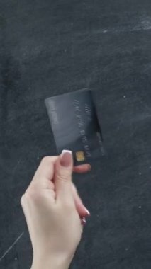 Dikey video. Para jestleri. Nakit para transferi. Kredi kartı hayranı bir kadın el ele tutuşuyor..