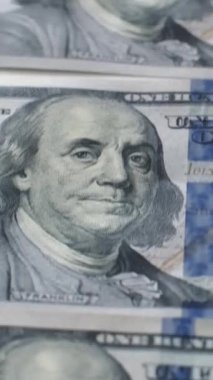 Dikey video. Amerikan doları. Para geçmişi. Amerikan parası. Küresel ekonomi Benjamin Franklin 'in portresi olan 100 dolarlık banknot yığını..