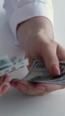 Dikey video. Tasarruf. Kâr geliri. Maaş ödemesi. Zengin iş kadınlarının eli 100 Amerikan doları nakit sayıyor..