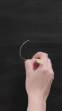 Dikey video. Olumlu düşün. Hayal gücü ilham verir. Kadın el, tahtaya güneş ışınları çiziyor..