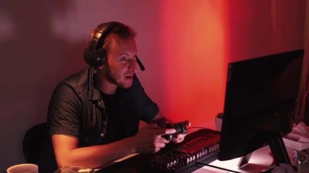 ゲームは失敗だ サイバー競争 トーナメントを失った後に失望感ジョイスティックを投げコンピュータをプレイ不幸な男性ゲーマー暗い部屋のインテリア — ストック動画