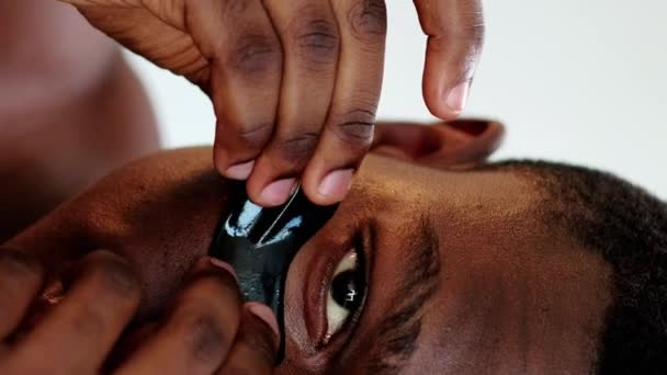 垂直录像 化妆品补丁 面部护理 防皱面罩应用黑液凝胶胶原蛋白在面部皮肤眼垫下的自信男子闭锁 — 图库视频影像