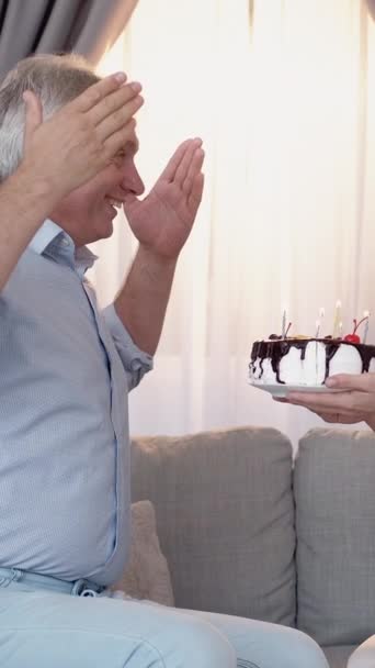 垂直录像 生日惊喜 快乐的家庭假日蛋糕 快乐的女人向丈夫献上喜庆的糕点 在家里点着蜡烛 — 图库视频影像