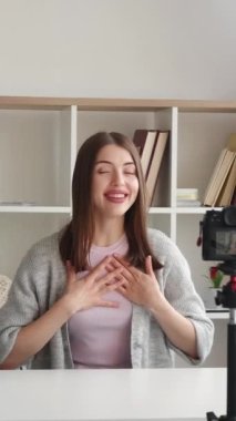 Dikey video. Nüfuzlu vlog. Canlı yayın. Çevrimiçi iletişim. Güler yüzlü, dost canlısı bir kadın internet içeriği kaydediyor, yurtiçinde konuşan takipçileri selamlıyor..