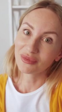 Dikey video. Çevrimiçi toplantı. Mesafe iletişimi. Dost canlısı kadın etkileyicisi ev içinde canlı yayın yapıyor..