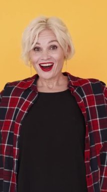 Dikey video. Saklambaç oyunu. Mutlu kadın. Orta yaşlı, etkileyici bir kadın. Gözleri görüyor ve sarıya bürünmüş sevinçle bakıyor..